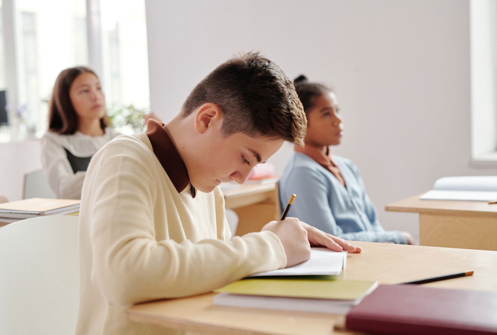 Illustrative image: students working in their notebooks.